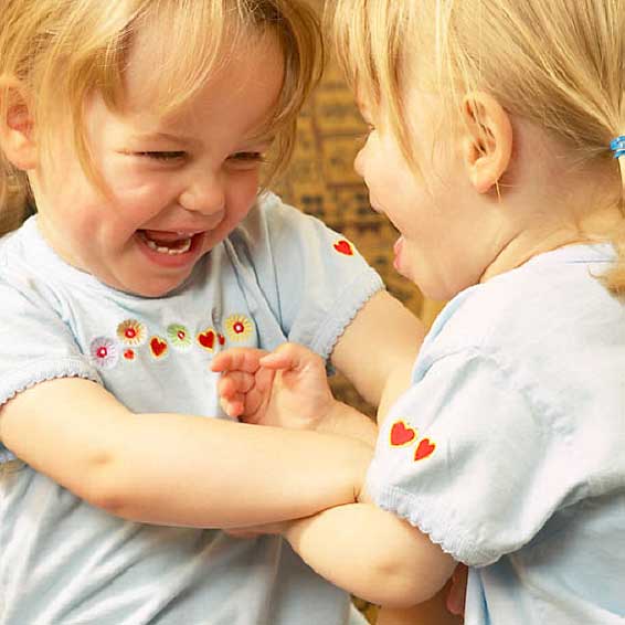 Little girls laughing and playing together
