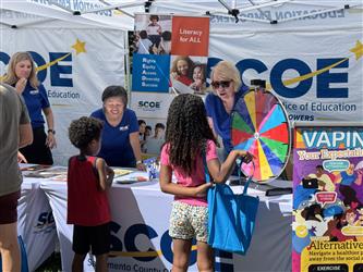 Employees engaging with the public at a literacy festival giving away books