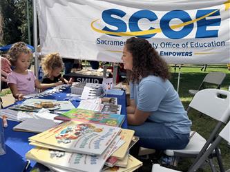 Employees engaging with the public at a literacy festival giving away books