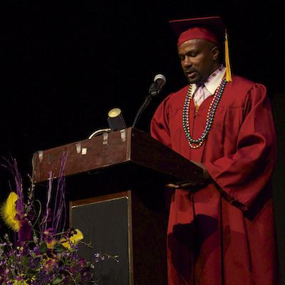 Client in cap and gown speaking at podium