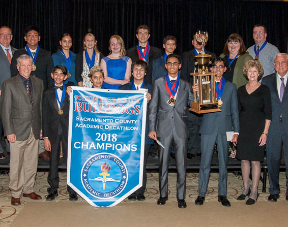 Folsom High School team posing with trophy and banner