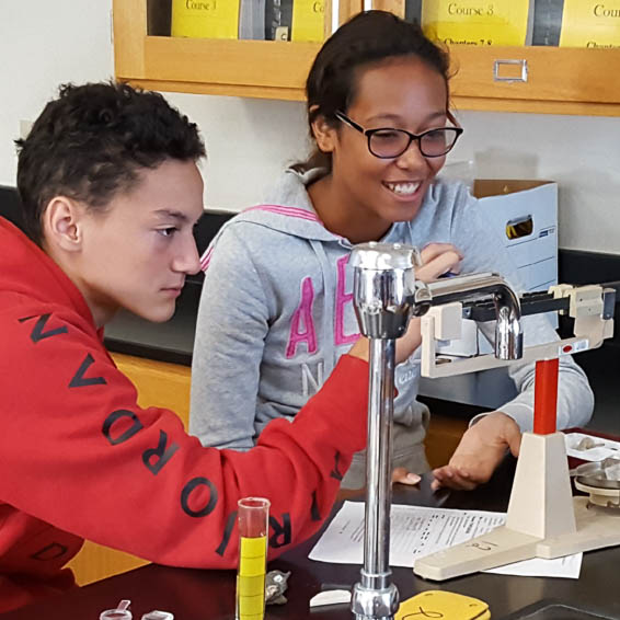 Students using a scale in a science classroom