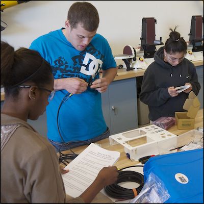 Students reading instructions and assembling electronics