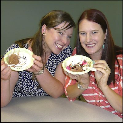 Employees posing with bowls of ice cream