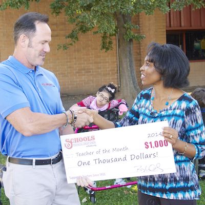 Oluchi Okemiri shakes hands with Leonard Willingham and receives a $1,000 check.