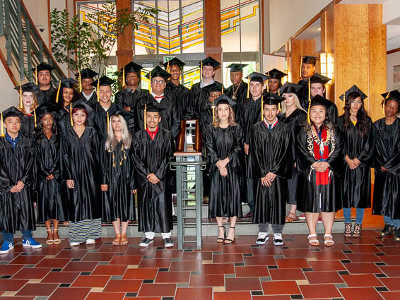 Group photo of graduates wearing black caps and gowns
