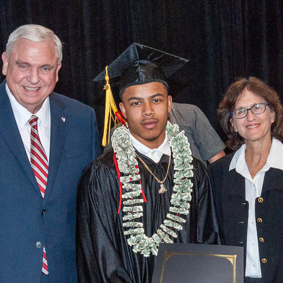 Graduate posing with dignitaries