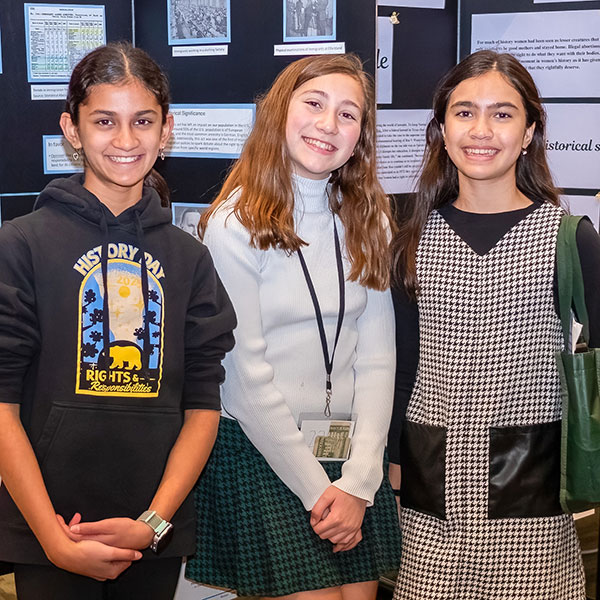 Students posing in front of projects