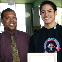 Student posing with staff and showing award