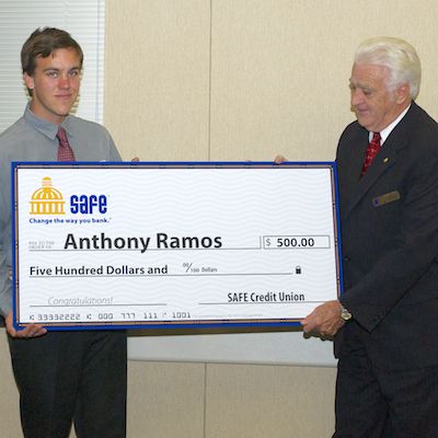 Anthony Ramos receiving large check from SAFE Credit Union