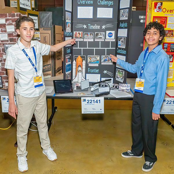 Students standing beside project