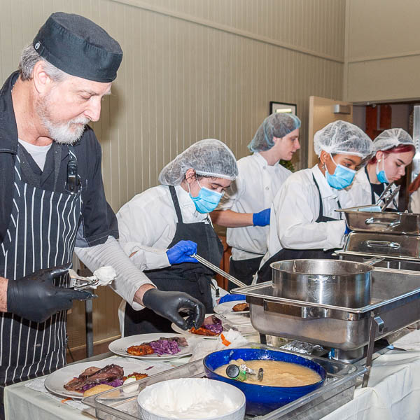 Chef Hazelton helping students plate food