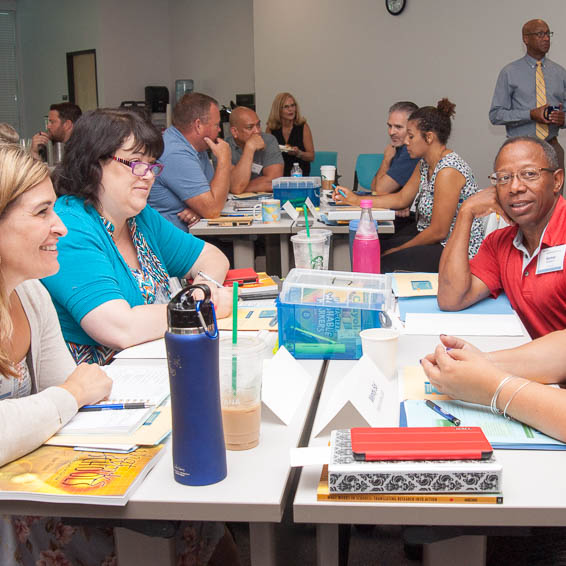 Teachers seated at tables in meeting room