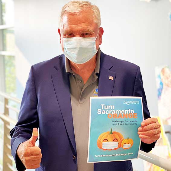 Superintendent Gordon holding poster and giving thumbs-up sign