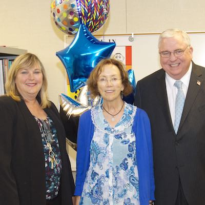 Lauren Roth and David Gordon presenting Marsha Cornwell with balloons