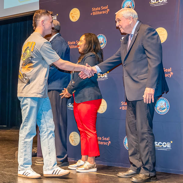 Superintendent Gordon shaking hands with a student