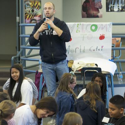 Standing adult lecturing seated students