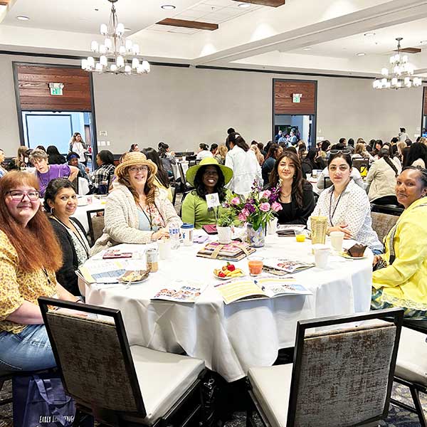 Wide photo of attendees at tables