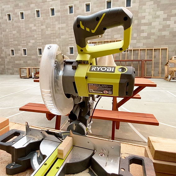 Miter saw in front of student projects in classroom