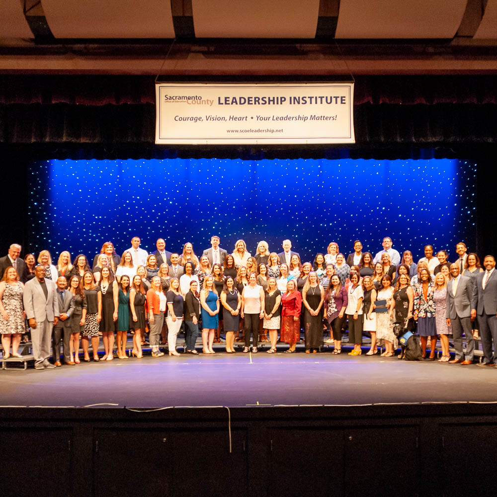 Large group of graduates posing on stage