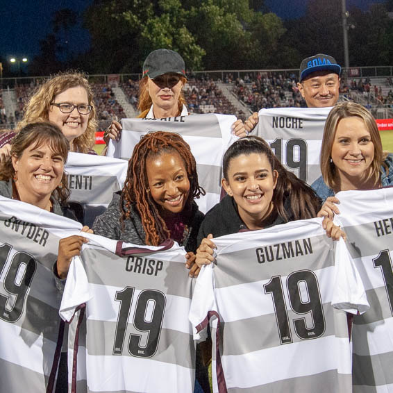 Teachers of the Year holding personalized jerseys