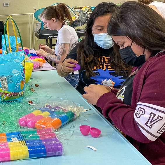 Students putting candy into plastic eggs