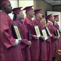 Certificate recipients in caps and gowns