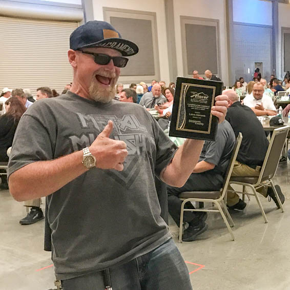 Client giving thumbs up while holding plaque