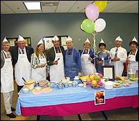 Cabinet members wearing aprons to serve ice cream