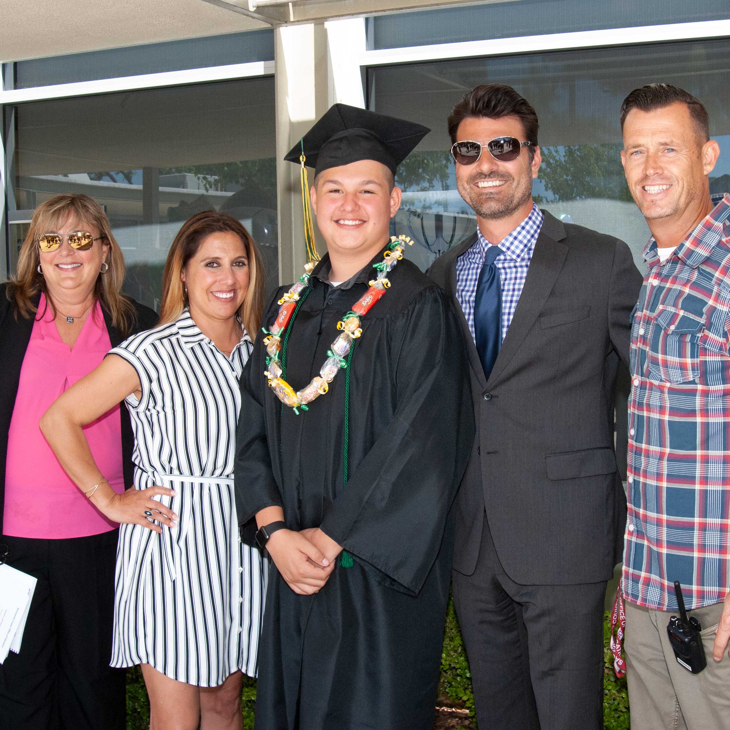 Staff posing outside with graduate