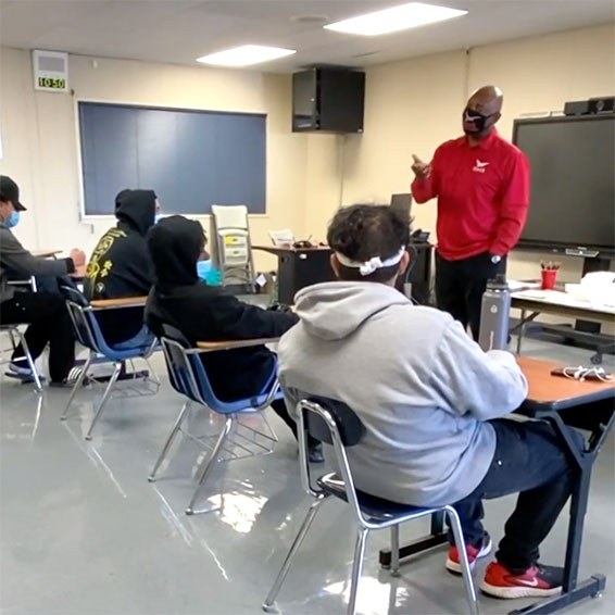 Students in a classroom, listening to a speaker