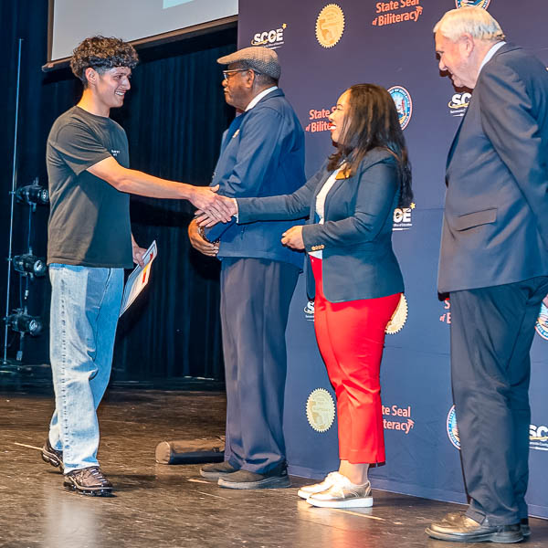 Vanessa Caigoy shaking hands with student