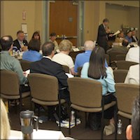 Seated meeting attendees listening to Greg Geeting speak