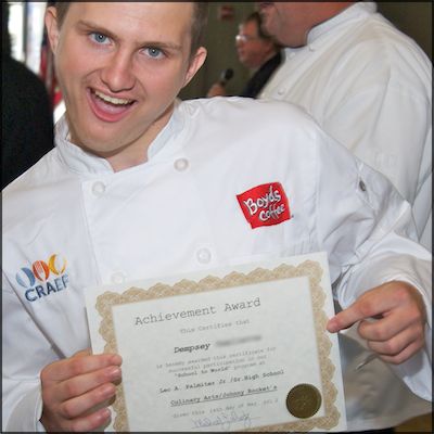 Student excitedly whiles while showing off achievement award certificate