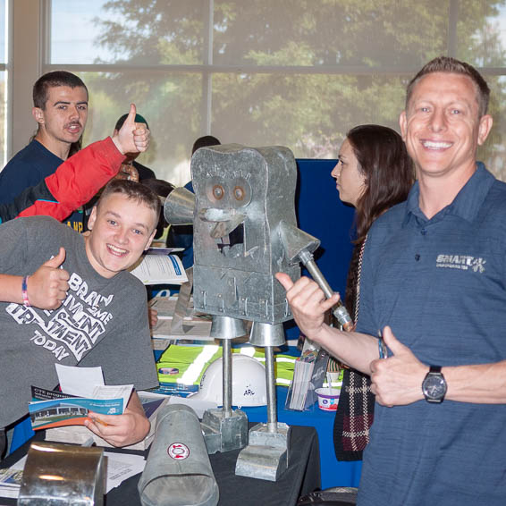 Smiling students posing with teacher