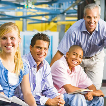 Teacher with seated students smiling