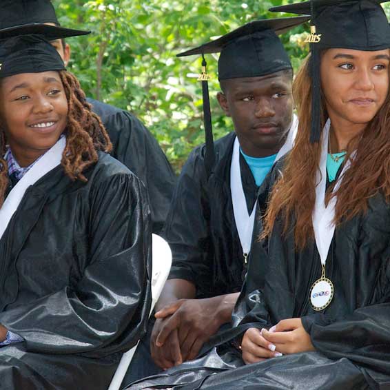 Seated graduates wearing caps and gowns