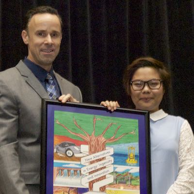 Craig Irish and Paula Cinco holding framed poster