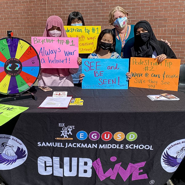 Samuel Jackman Middle School Club Live students posing with bicycle and pedestrian safety signs