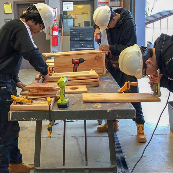 Students using woodworking tools to construct duck boxes