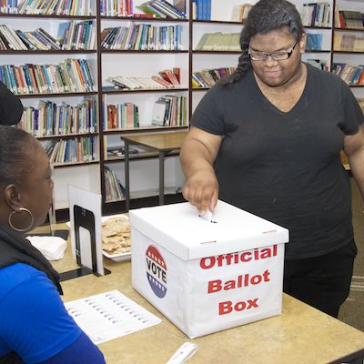 Student depositing ballot in ballot box