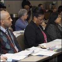 Seated audience members looking at handouts