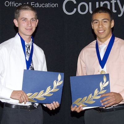 Smiling scholarship recipients holding certificates