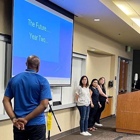 DLAC participants presenting in front of screen