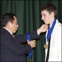 Board member presenting medal to student