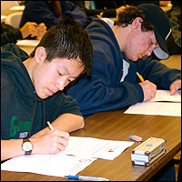 Seated students taking practice exams