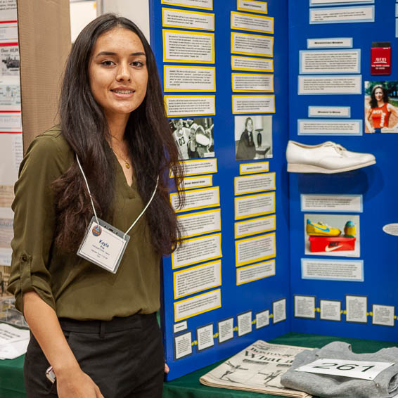 Student standing in front of project display