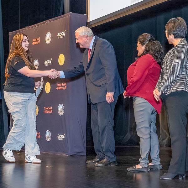 Student shaking hands with dignitaries