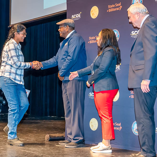 Al Brown shaking hands with student