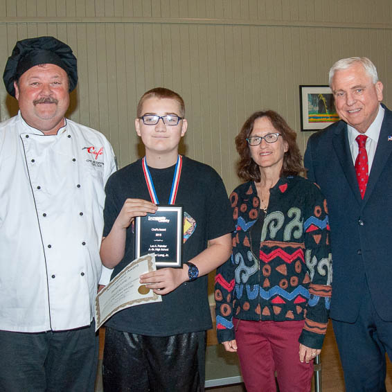 Student holding plaque